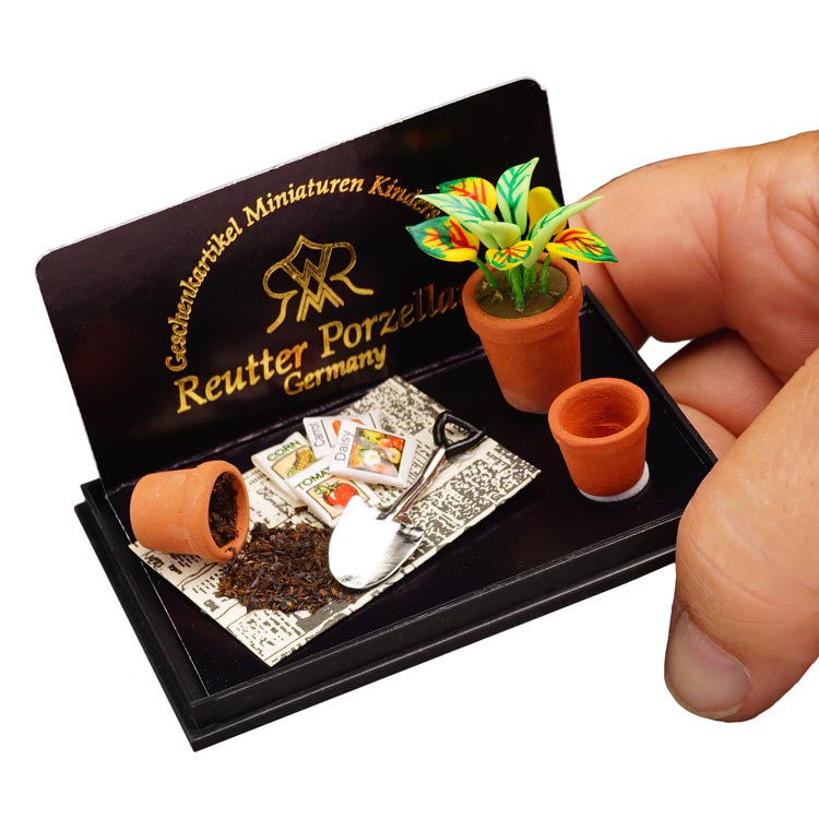 Platz zum Eintopfen mit Gartenschaufel, Blumen, Töpfen und Zeitungspapier