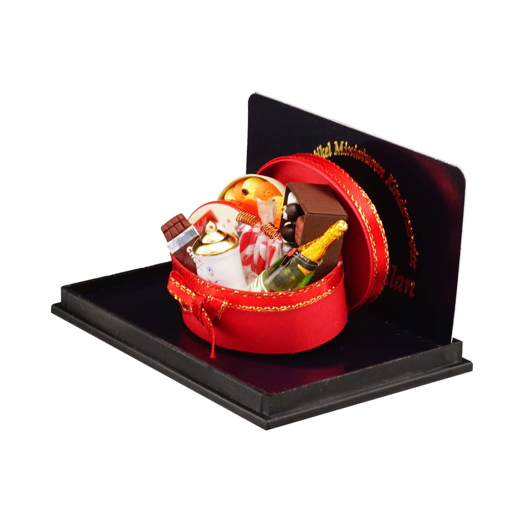 Ovale Geschenkbox gefüllt mit Schokolade, Champagner, Pralinen und weiteren Köstlichkeiten