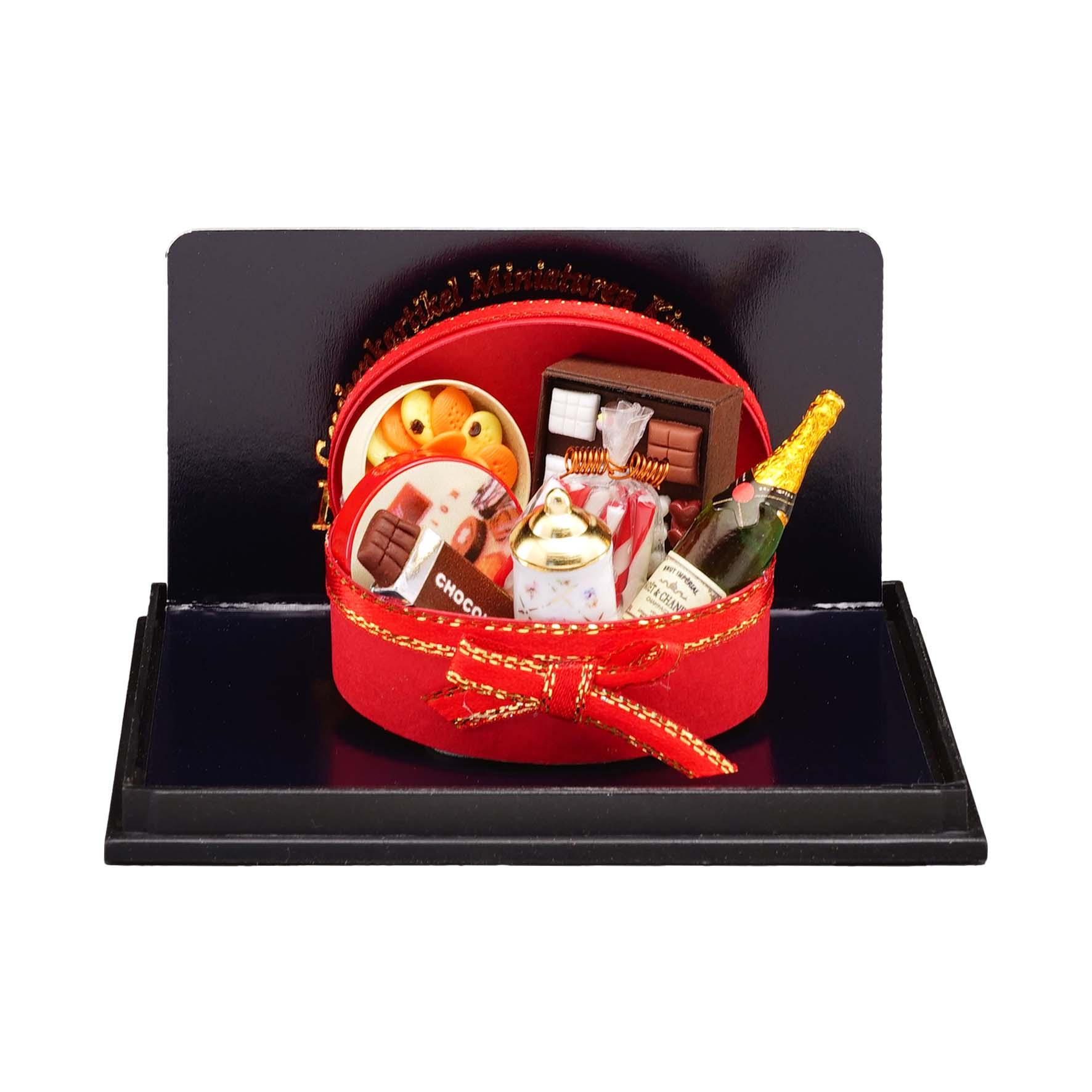 Ovale Geschenkbox gefüllt mit Schokolade, Champagner, Pralinen und weiteren Köstlichkeiten