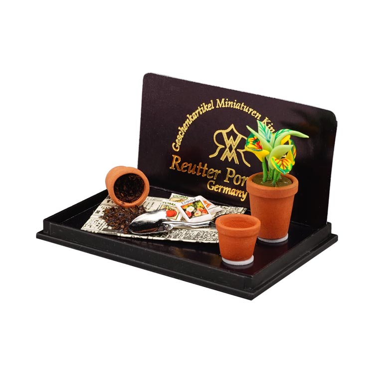 Platz zum Eintopfen mit Gartenschaufel, Blumen, Töpfen und Zeitungspapier