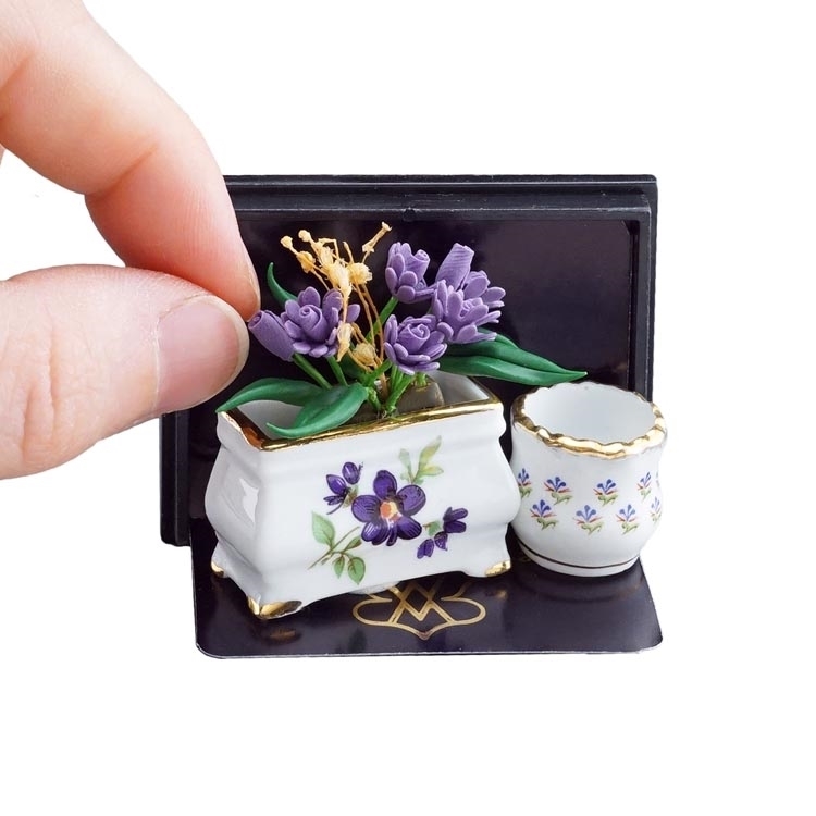 Blumenkasten mit lila Blumen und Blumentopf