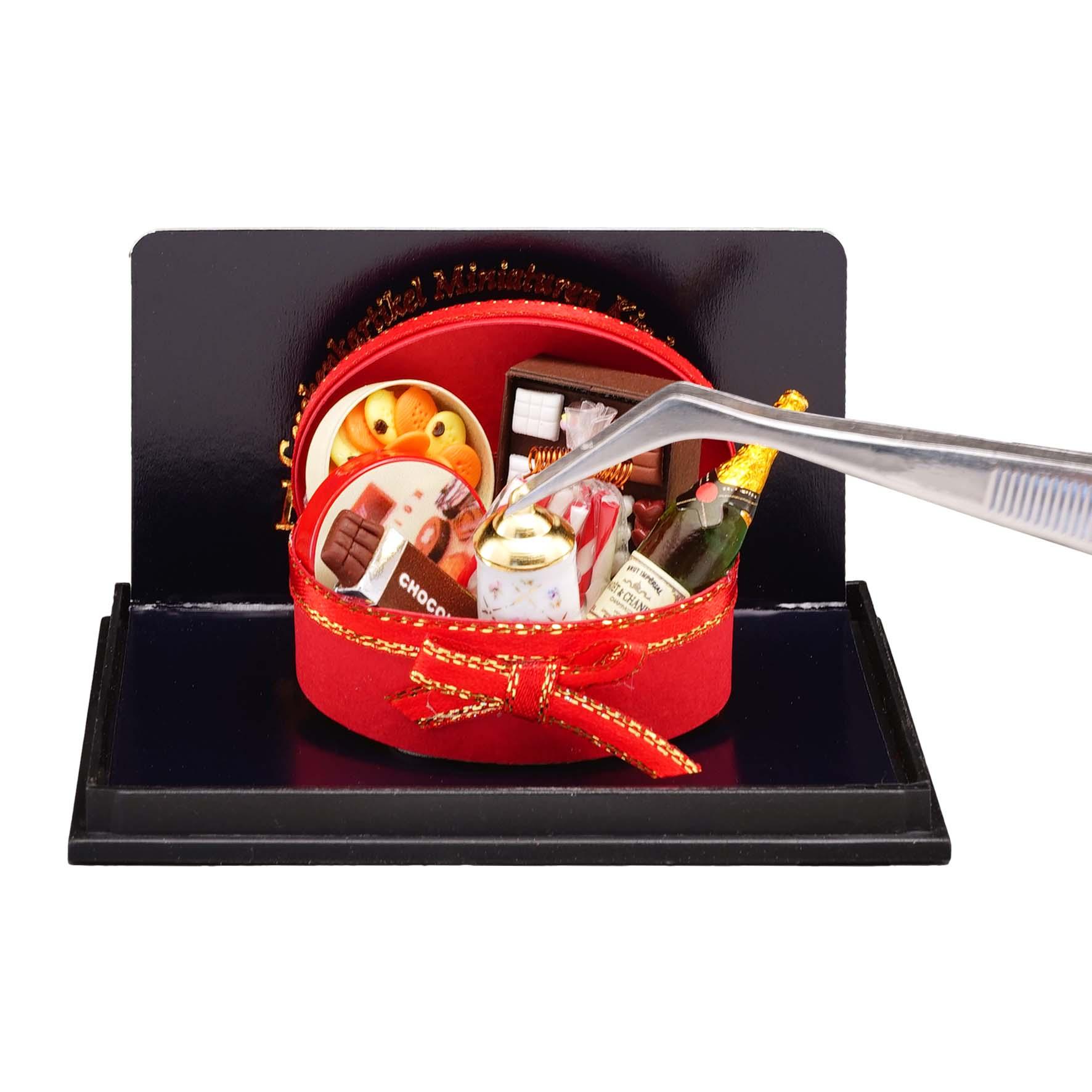 Ovale Geschenkbox gefüllt mit Schokolade, Champagner, Pralinen und weiteren Köstlichkeiten